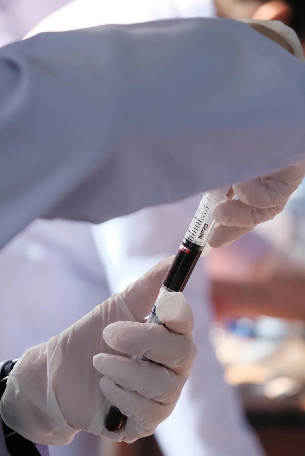 A person in white gloves is holding a syquet