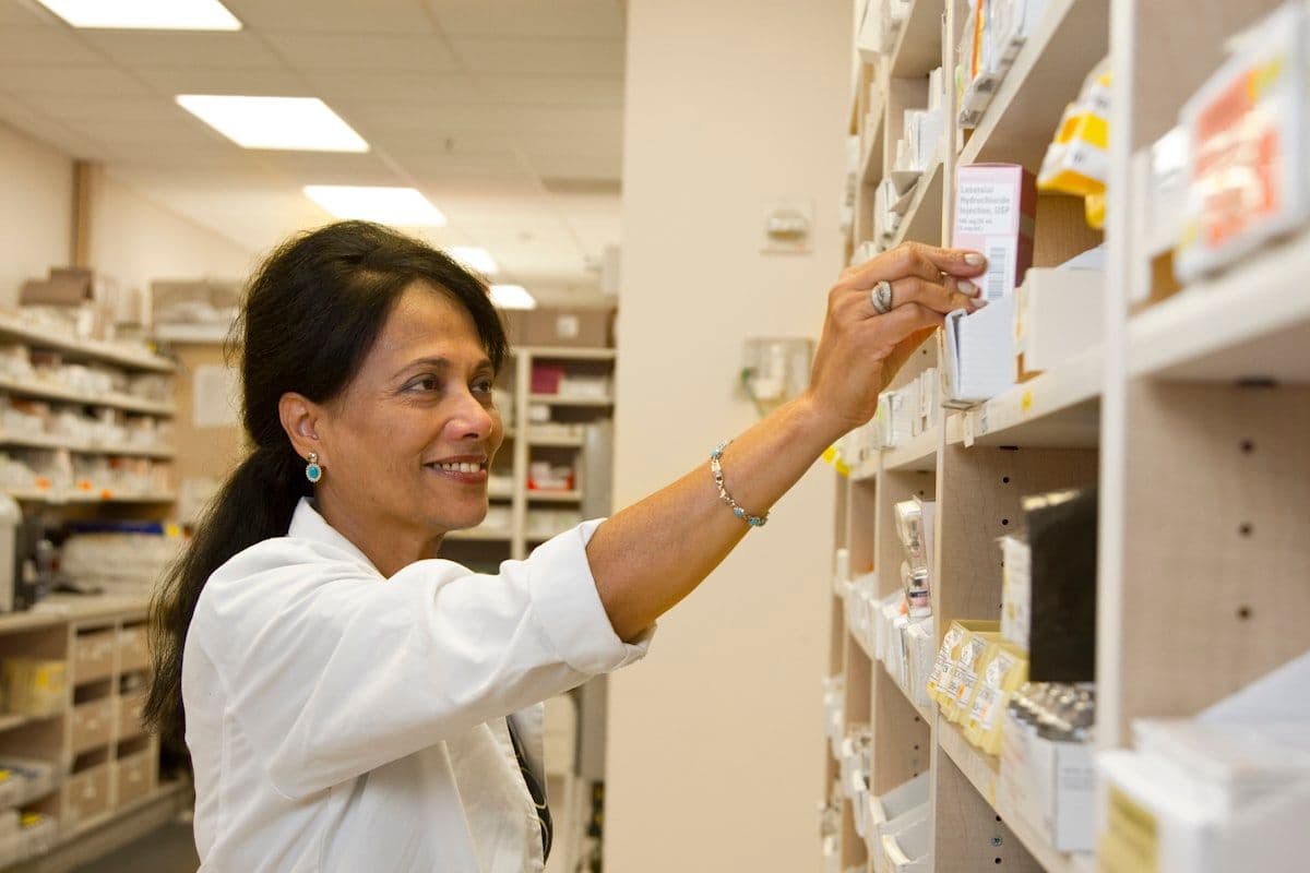 A pharmacist holding a box of medication