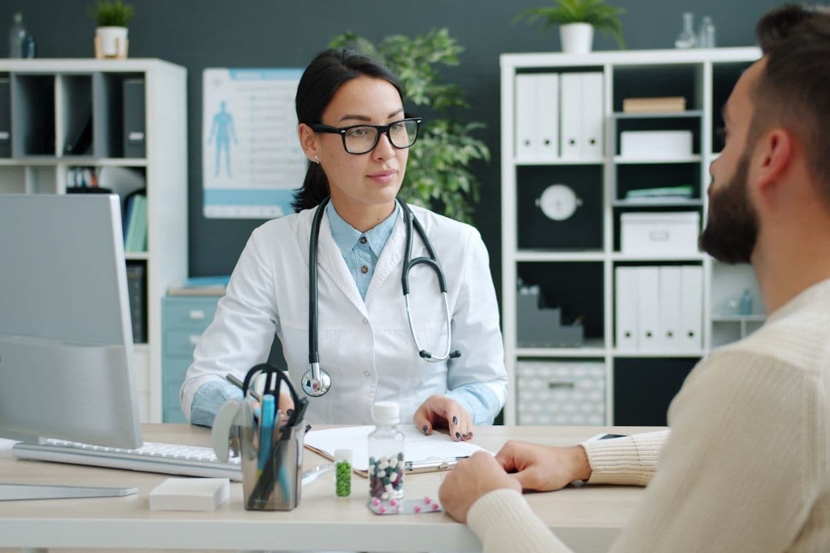 A healthcare professional consulting a patient at a desk