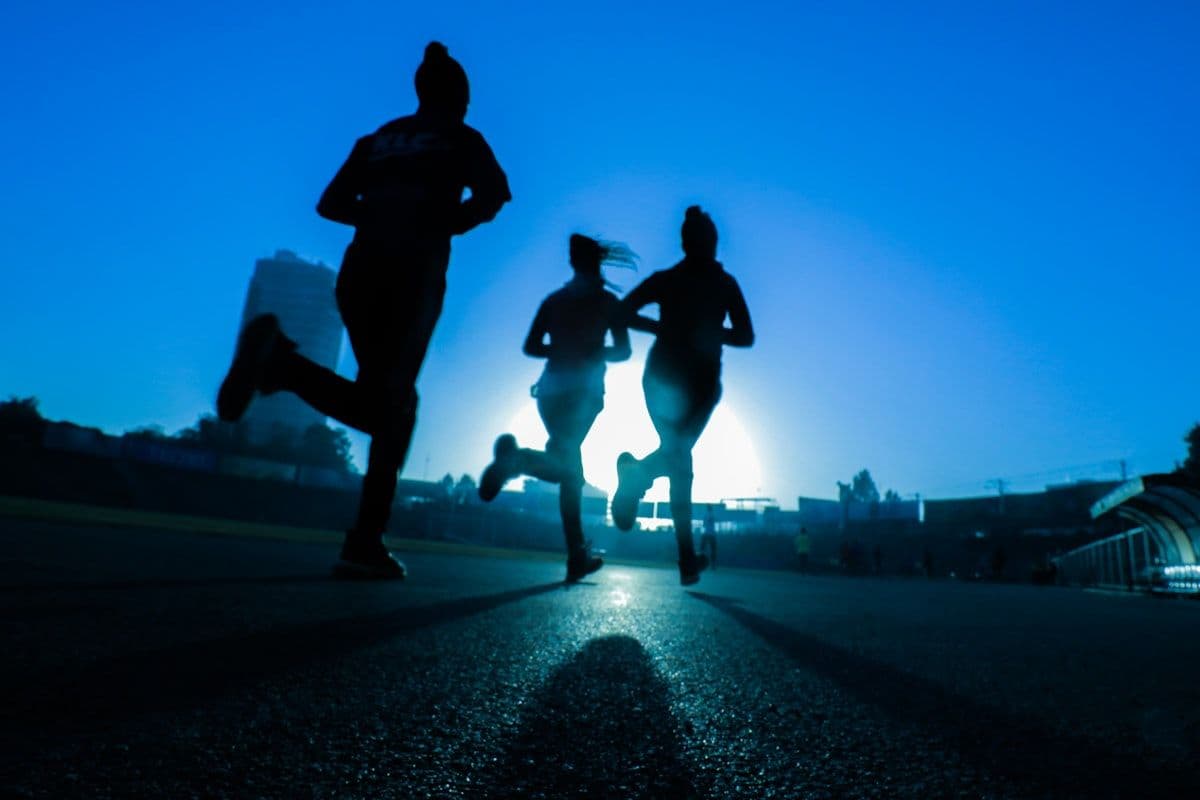 Three runners jogging together at dusk