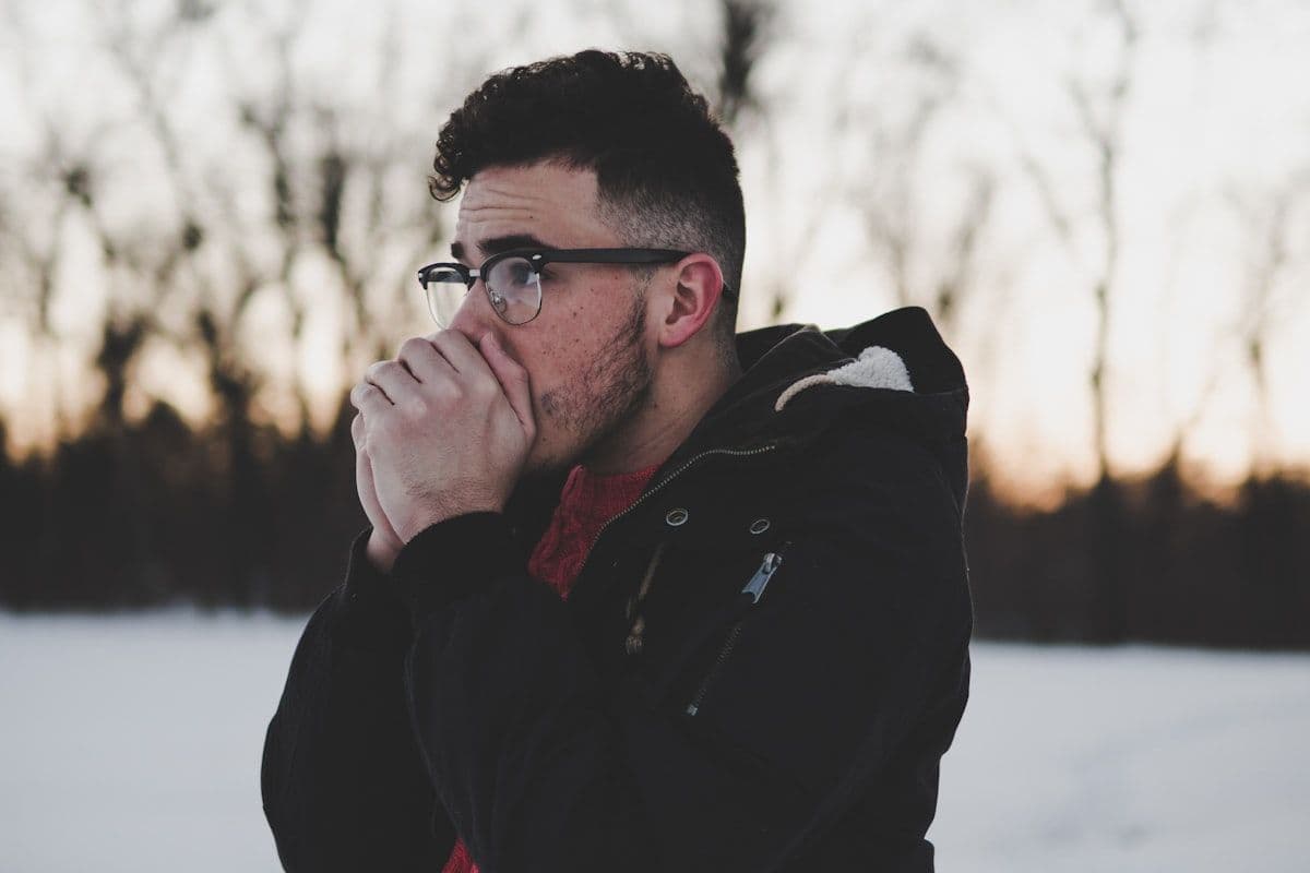 A man covering his mouth while coughing