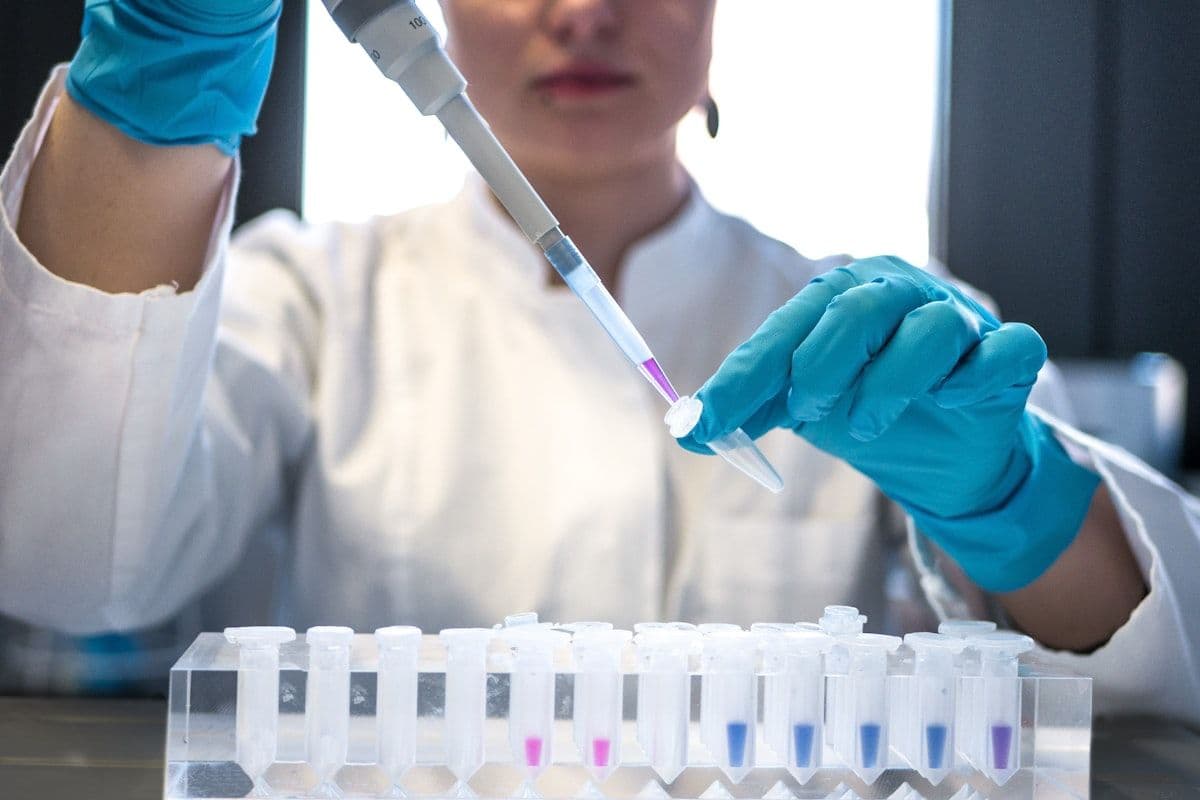 A scientist using a pipette with laboratory test tubes