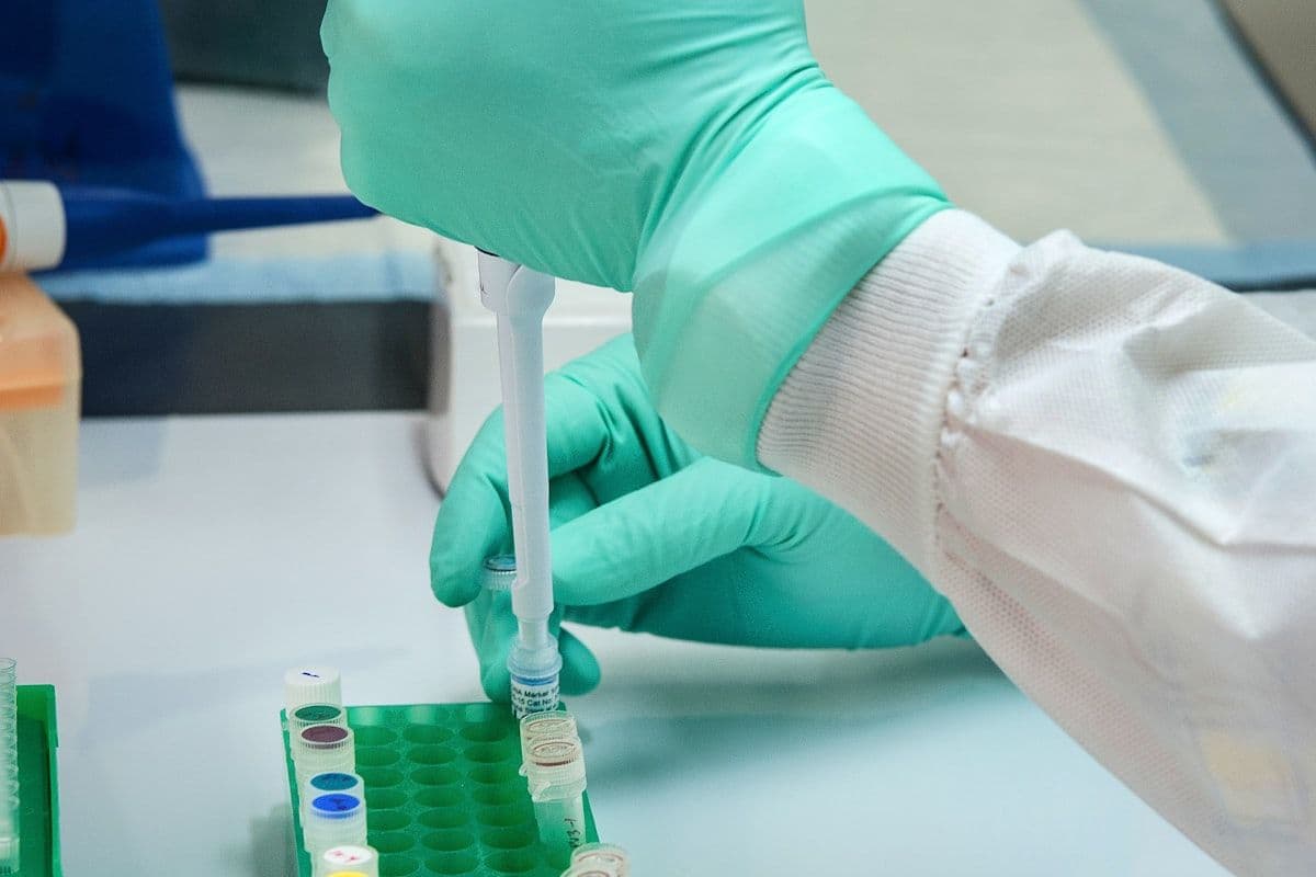 A healthcare worker holding a labelled specimen container